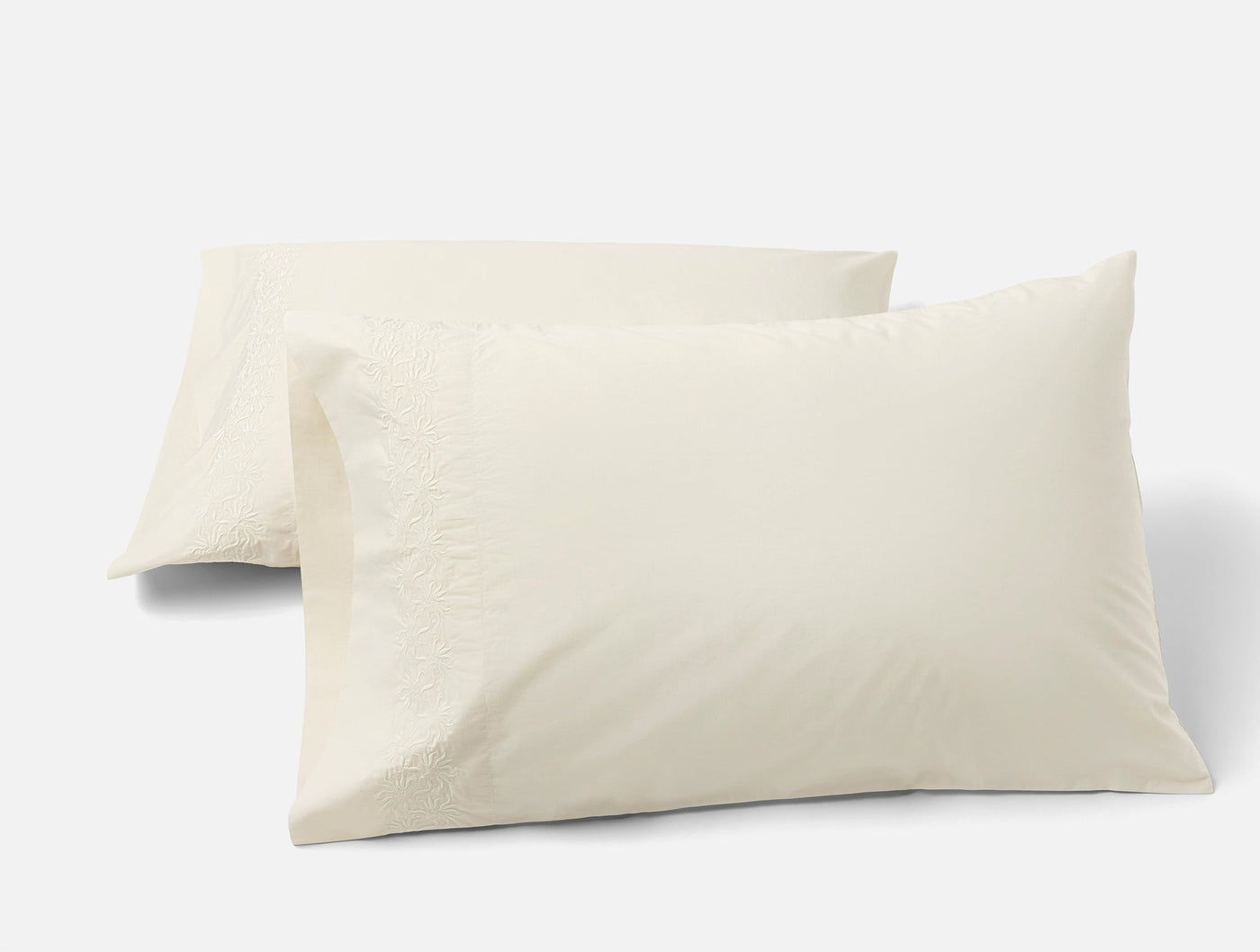 Pair of Coyuchi Refined Percale pillowcases in ivory, shown stacked on white background.