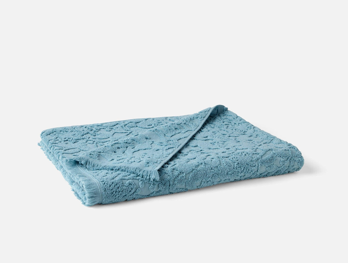 Coyuchi Wildflower bath towel folded, showing sky blue tonal floral terry texture.