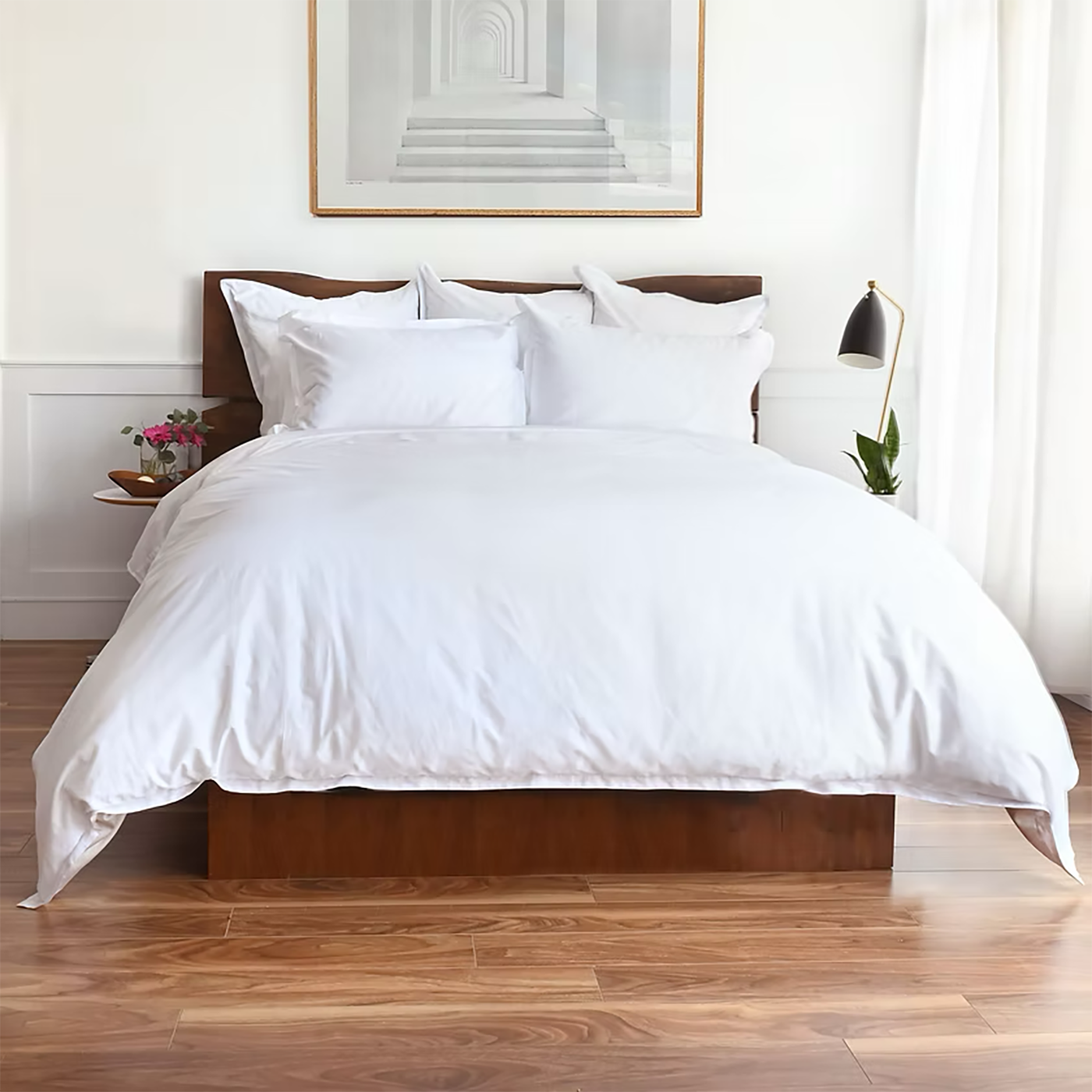 St. Geneve Capri Sateen white fitted sheet styled on a made bed in a bright bedroom.