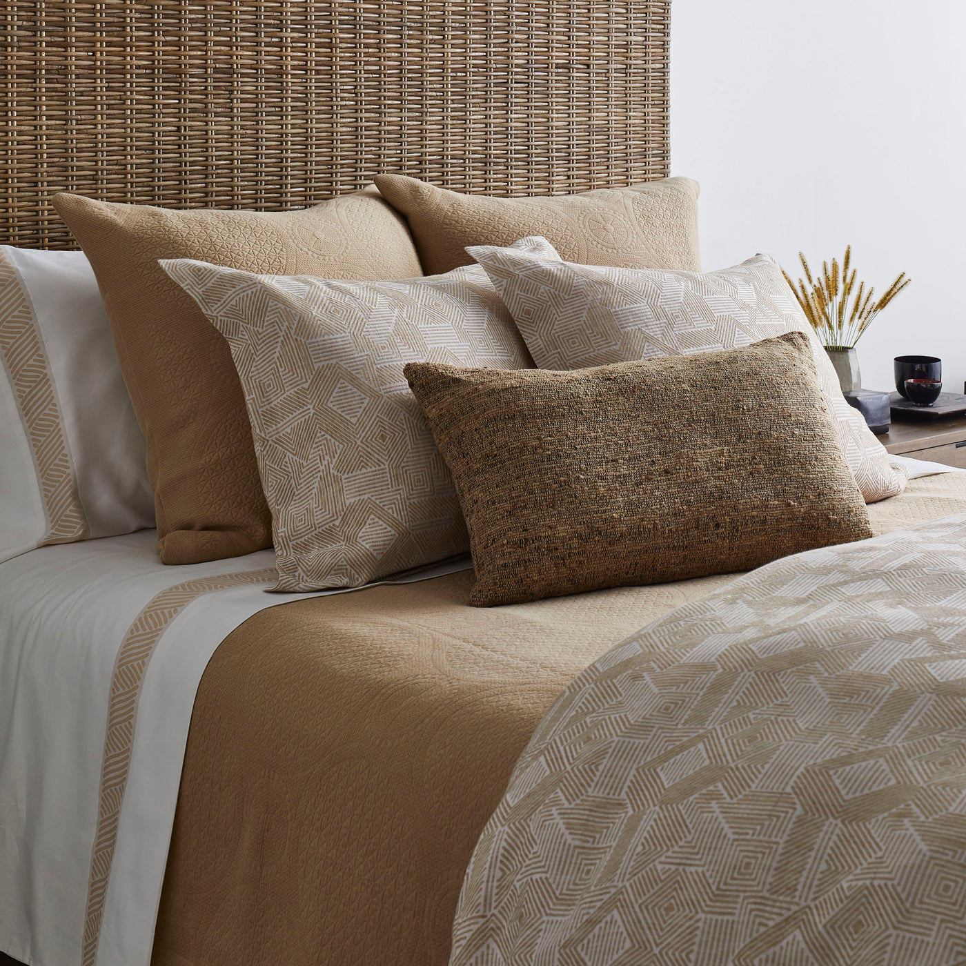 Ann Gish Sashiko duvet set styled on bed with layered camel and ivory pillows.
