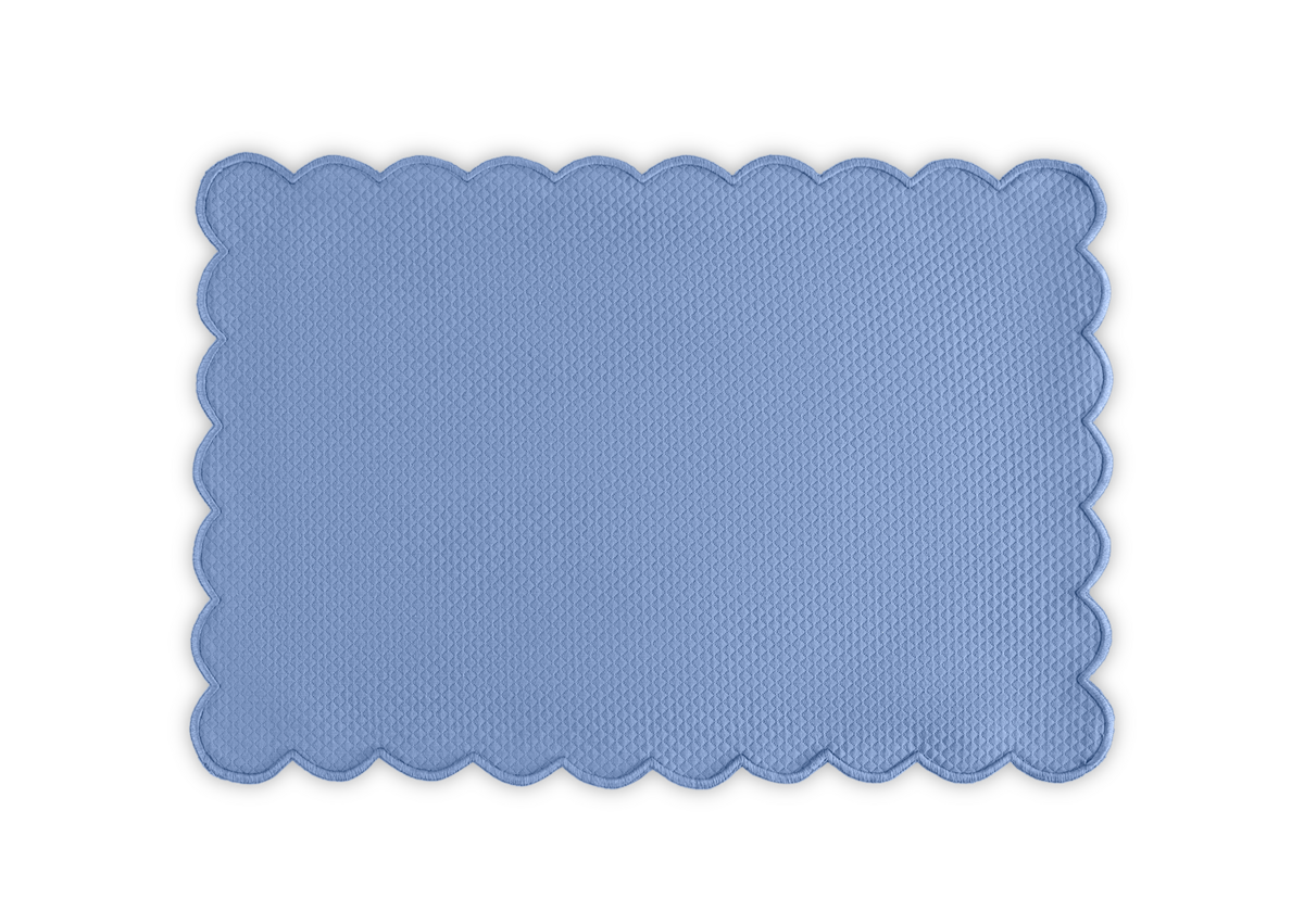 The Matouk Savannah Gardens | Placemat Set features rectangular blue placemats with a diamond pique texture and scalloped edges, shown on a white background. Part of the elegant Matouk table linens collection.