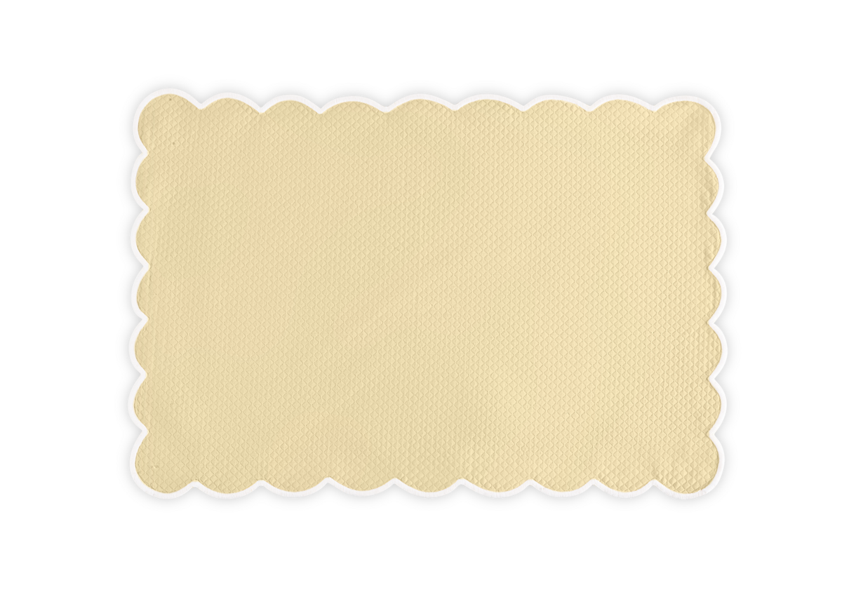 The Savannah Gardens Placemat Set by Matouk features rectangular beige placemats with a textured diamond pique surface and scalloped edges, inspired by classic Matouk table linens, displayed on a plain white background.