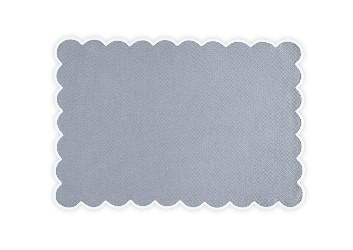 The Matouk Savannah Gardens Placemat Set features rectangular light gray placemats with scalloped edges in diamond pique, beautifully set against a white background—an elegant addition to your table linens collection.
