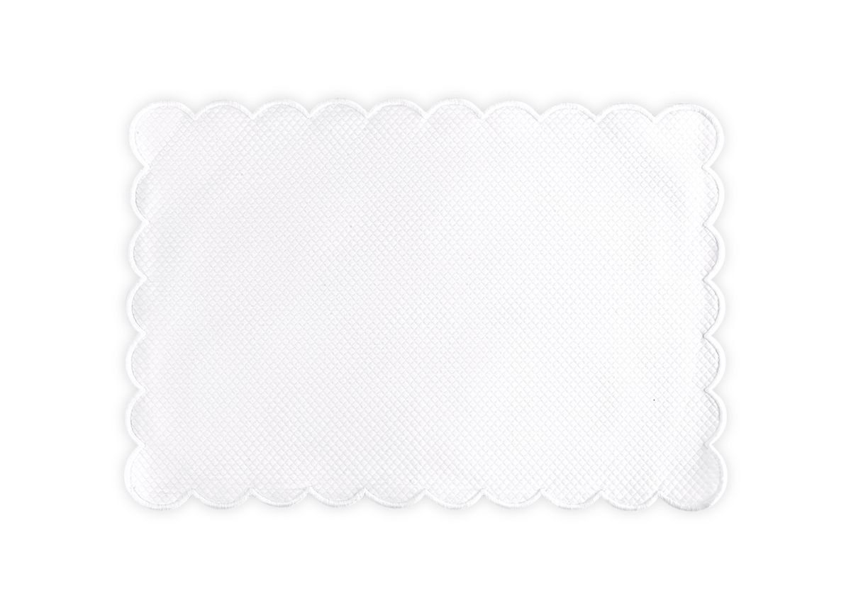 The Savannah Gardens Placemat Set by Matouk features rectangular white placemats with scalloped edges and a subtle diamond pique pattern, displayed on a plain background.