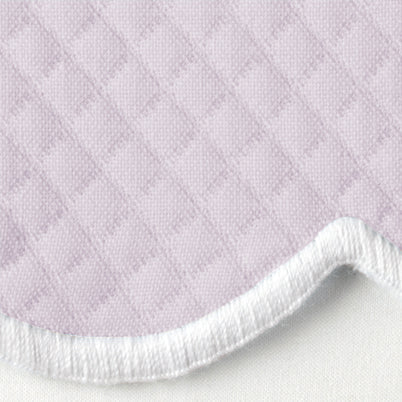 Close-up of lavender quilted fabric with white terry reverse and curved edge detail.