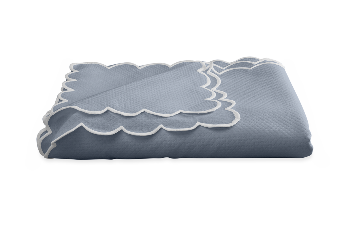 The Savannah Gardens Tablecloth by Matouk, in blue diamond pique with a white scalloped edge, is folded and displayed on a plain white background. Easy-care design, perfect for everyday use.