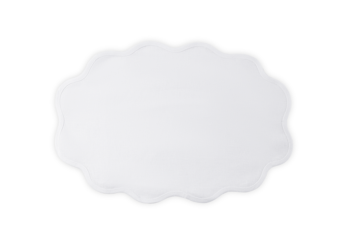 The Matouk Scallop Edge Placemat Set features white, oval-shaped linen placemats with scalloped edges—ideal for a unique tablescape or pairing with matching Scallop Edge Napkins.