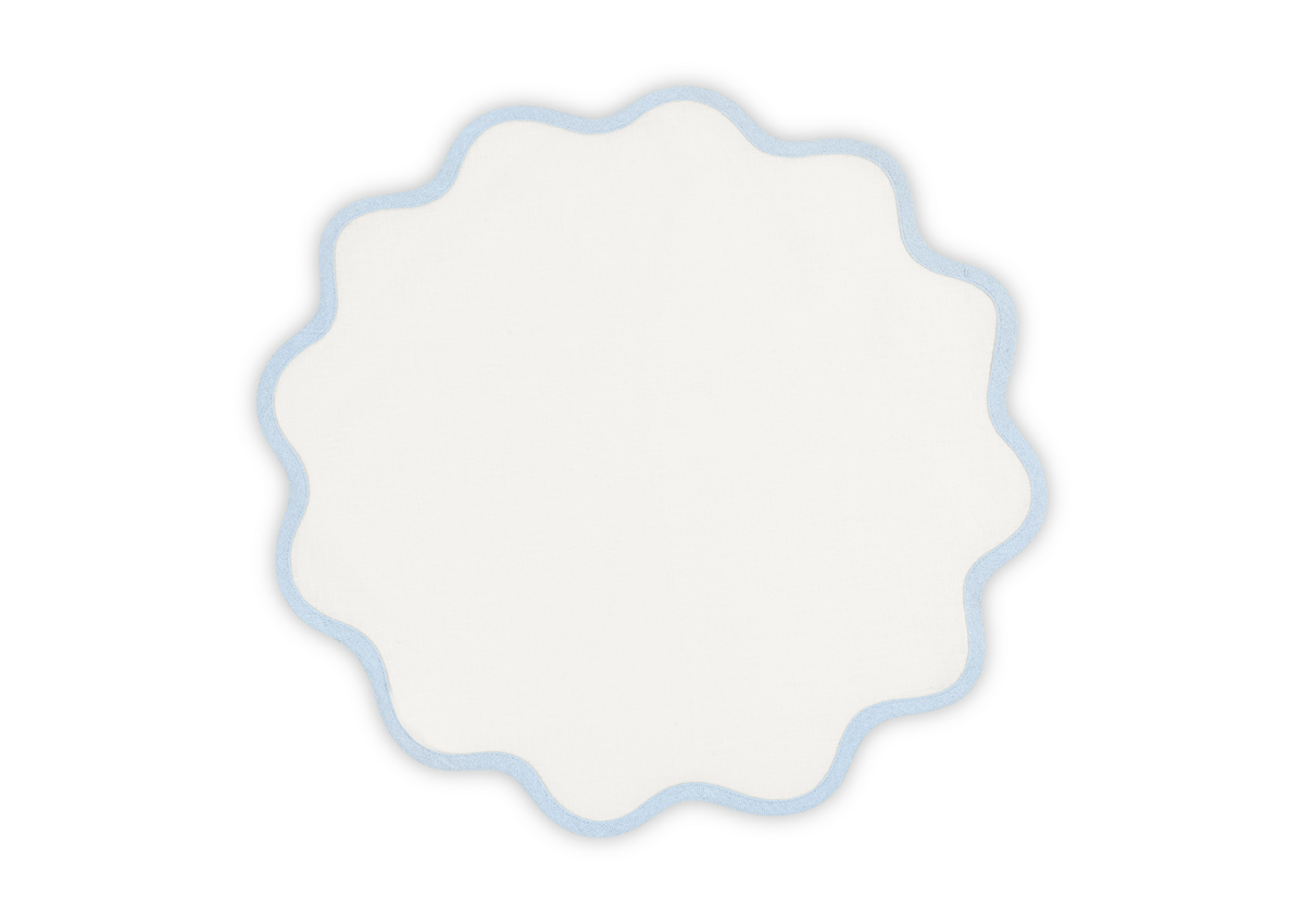 The Matouk Scallop Edge Placemat Set features white, round linen placemats with light blue scalloped edges—ideal for a unique tablescape, shown on a plain background.