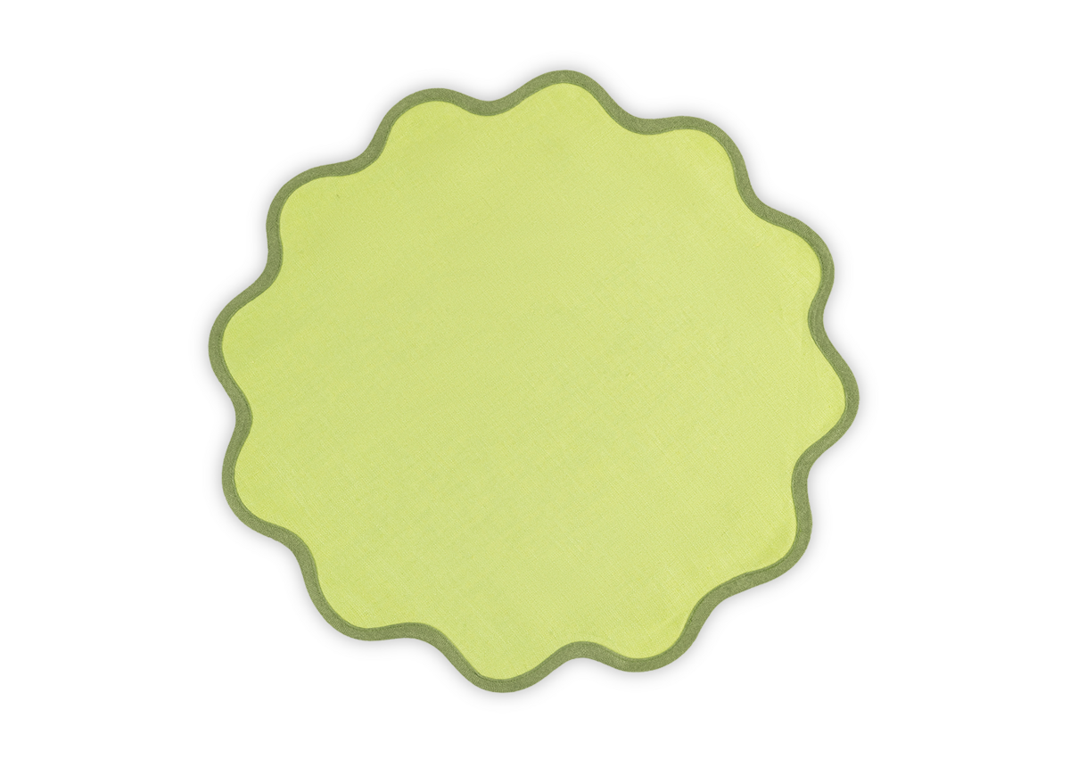 The Matouk Scallop Edge Placemat Set features round, yellow-green linen placemats with wavy, scalloped edges and darker green borders, ideal for a unique tablescape and shown against a white background.