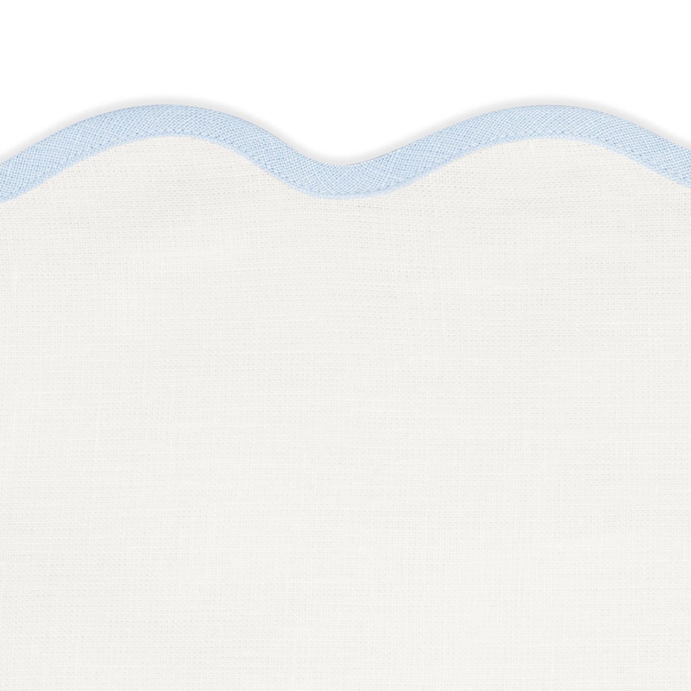 Close-up of Matouk’s Scallop Edge | Napkin Set in white with light blue trim, ideal for adding a unique touch to your tablescape or pairing with linen placemats.