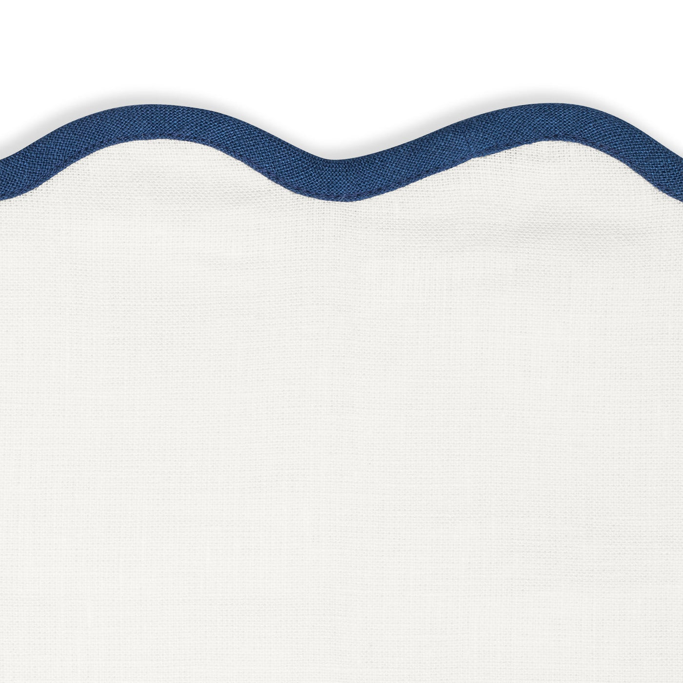 Matouk’s Scallop Edge | Napkin Set features white textured fabric with a blue-trimmed scalloped edge, adding charm and pairing perfectly with your favorite linen placemats.