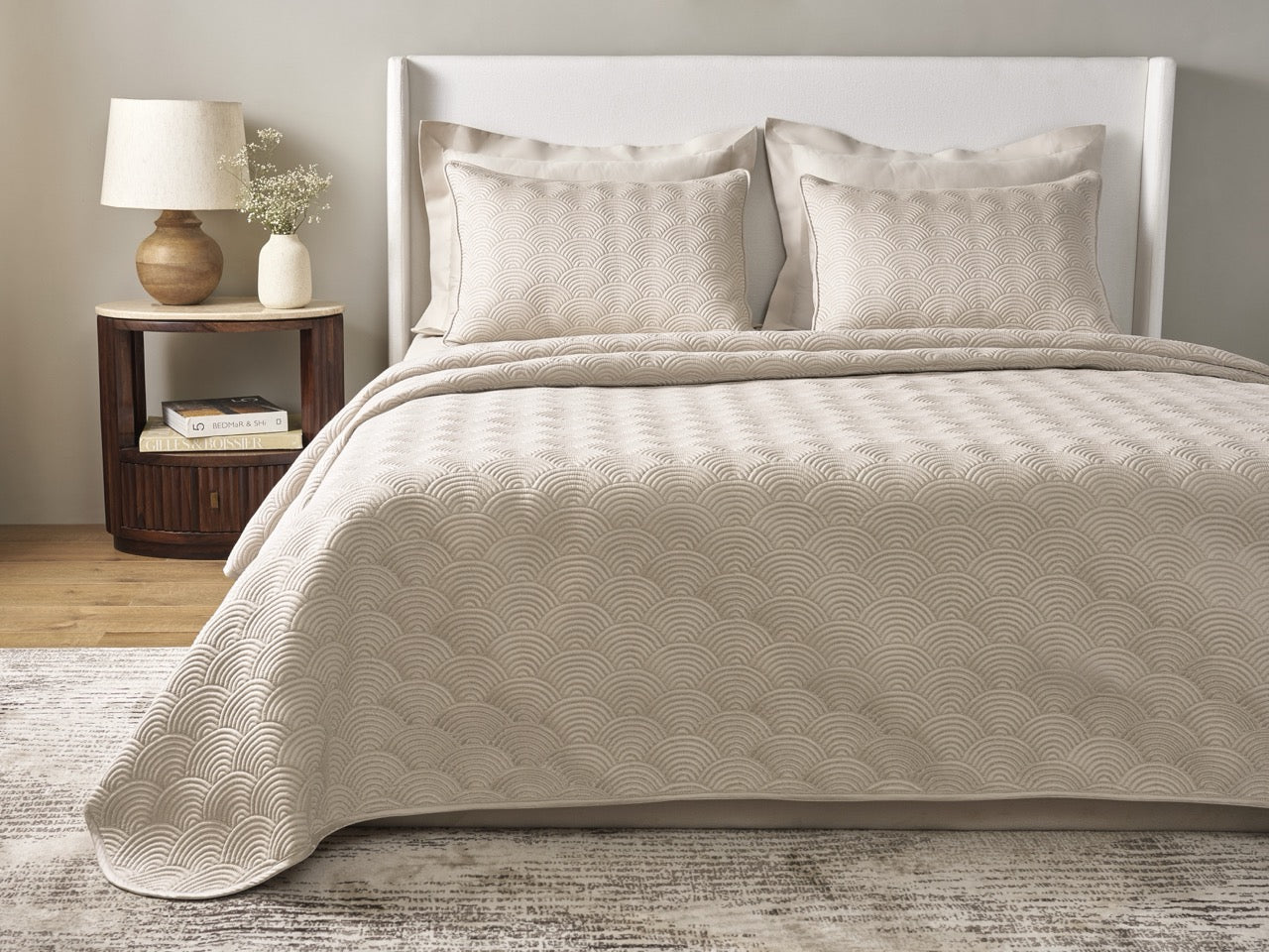 Ann Gish Scallop coverlet set in sand, styled on bed with matching shams in neutral bedroom.