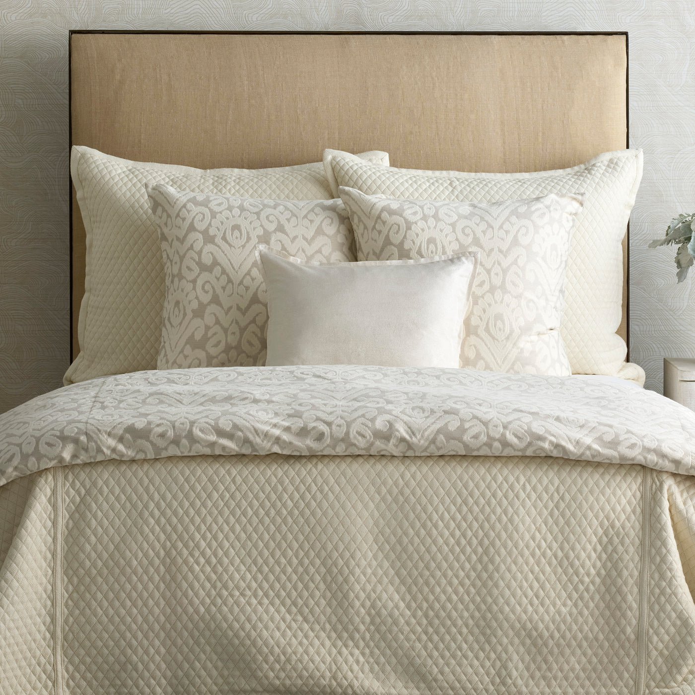 Ann Gish Scepter duvet cover in ivory, styled on bed with coordinating scroll-embroidered pillows.