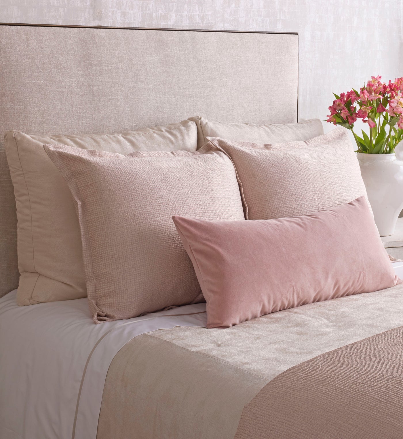 Bed styled with layered blush and taupe pillows; Ann Gish Screen coverlet in neutral tones visible.