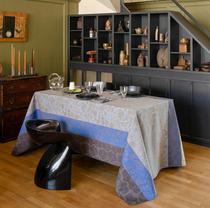 Close-up of Le Jacquard Français Cottage Cotton tablecloth in slate and cobalt blue border, set on dining table.
