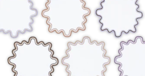 The Wave Cocktail Napkin Set by Matouk features six wavy-edged circular napkins with two-tone muted borders, displayed on a white background.