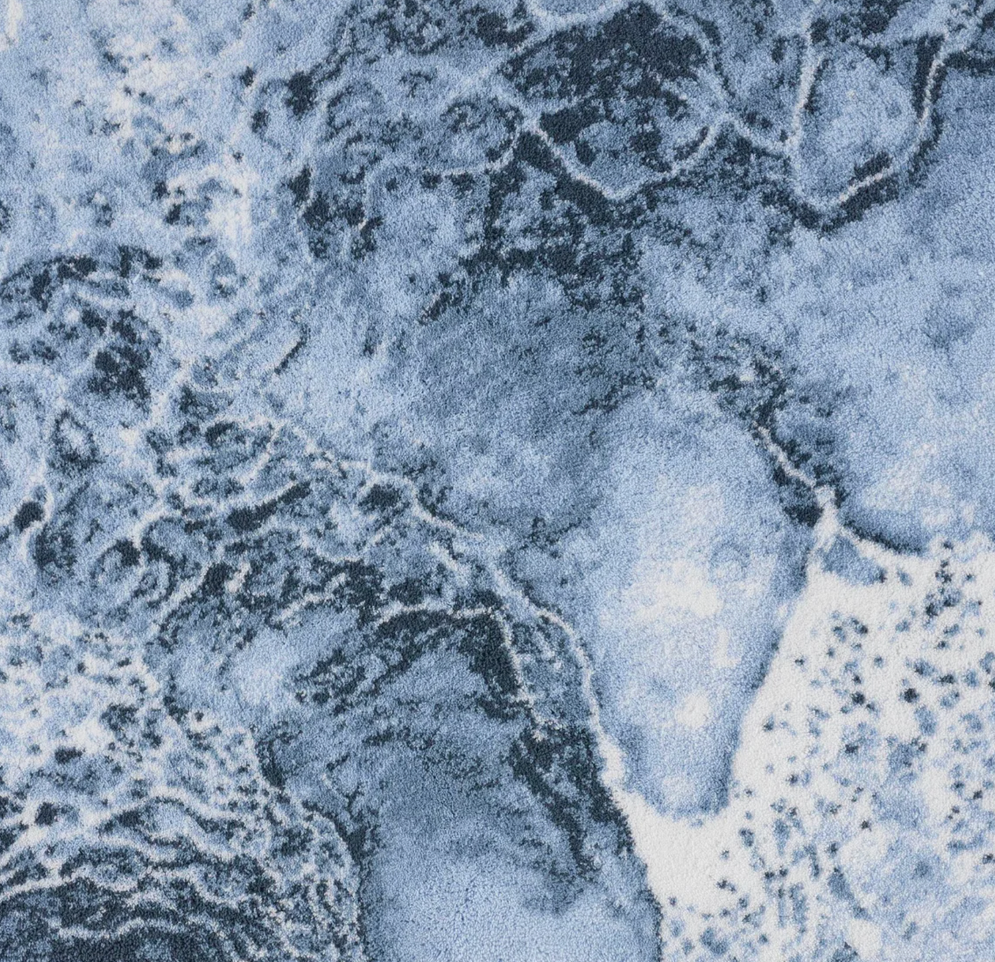 Close-up of Nazare rug surface showing ocean-inspired slate blue and white pattern detail.