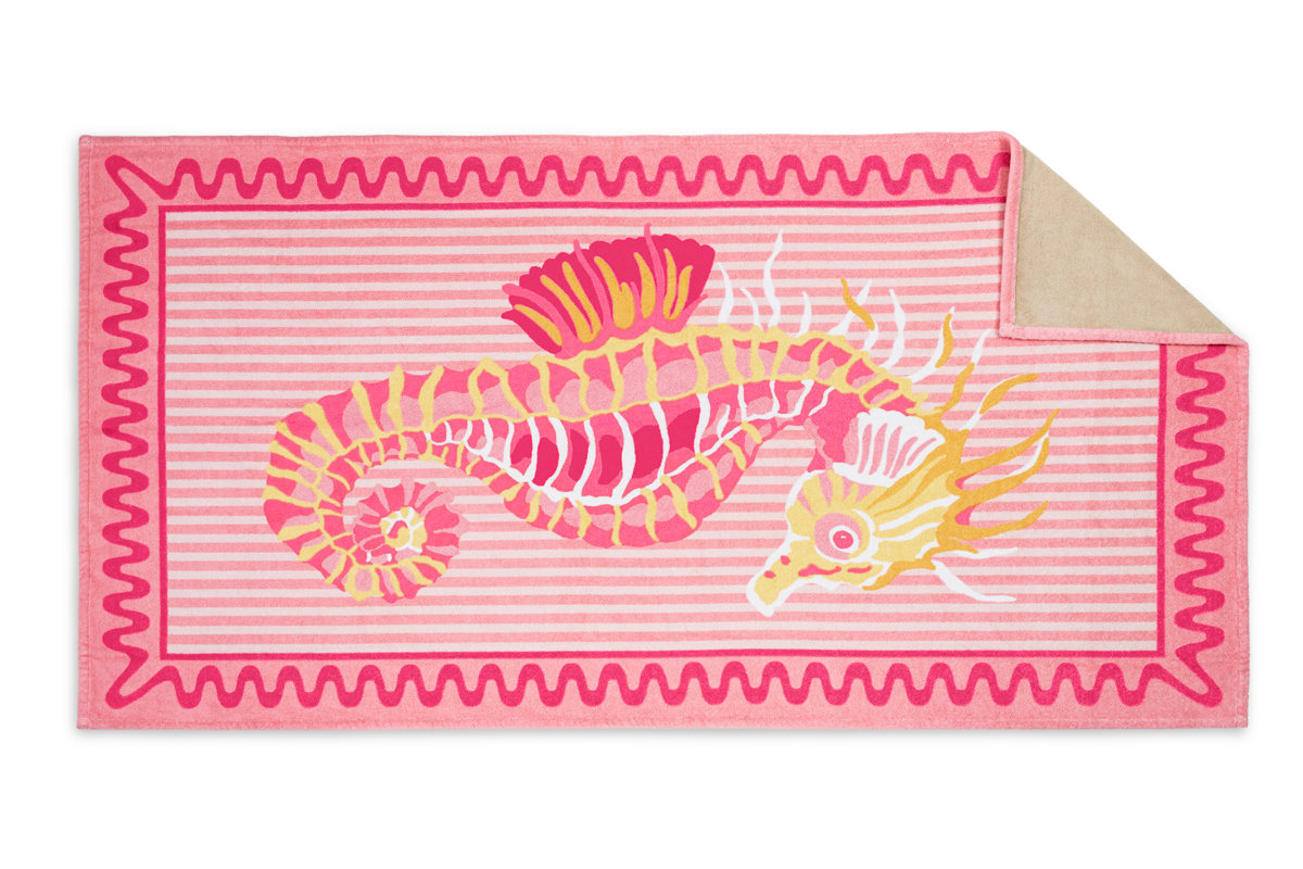 Part of Matouk’s beach collection, the Seahorse Beach Towel showcases pink and beige stripes, a bold yellow and pink seahorse at the center, and a playful pink wavy border.