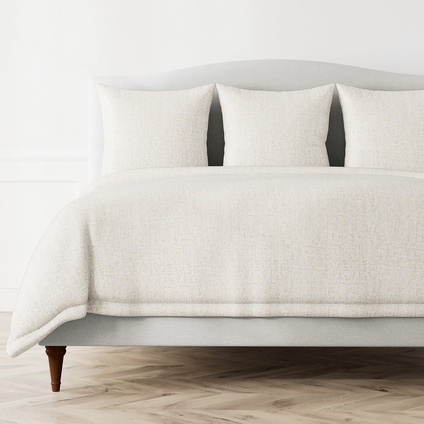 Ann Gish Serac duvet cover in ivory, textured weave, styled on a made bed with matching shams.