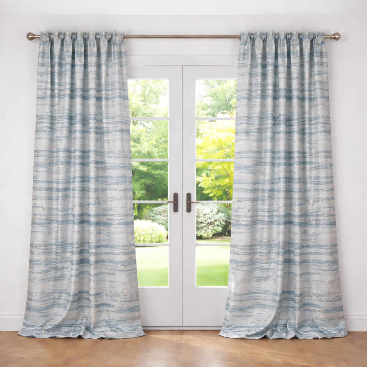 Ann Gish Serenity curtains in soft blue-grey marble print, hung on a brass rod framing French doors.