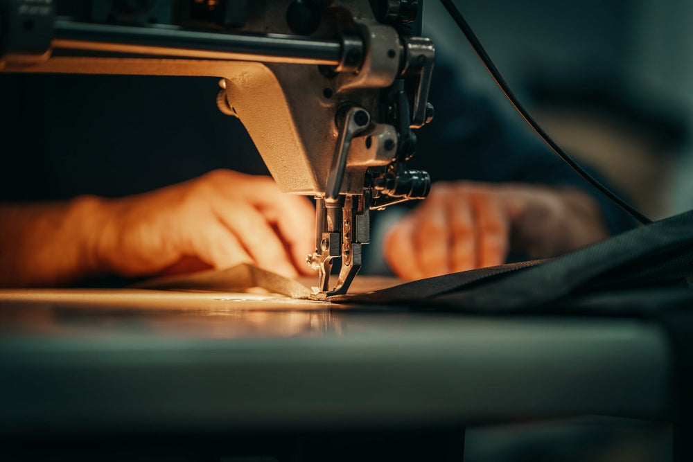 Image of hands pushing fabric through sewing machine