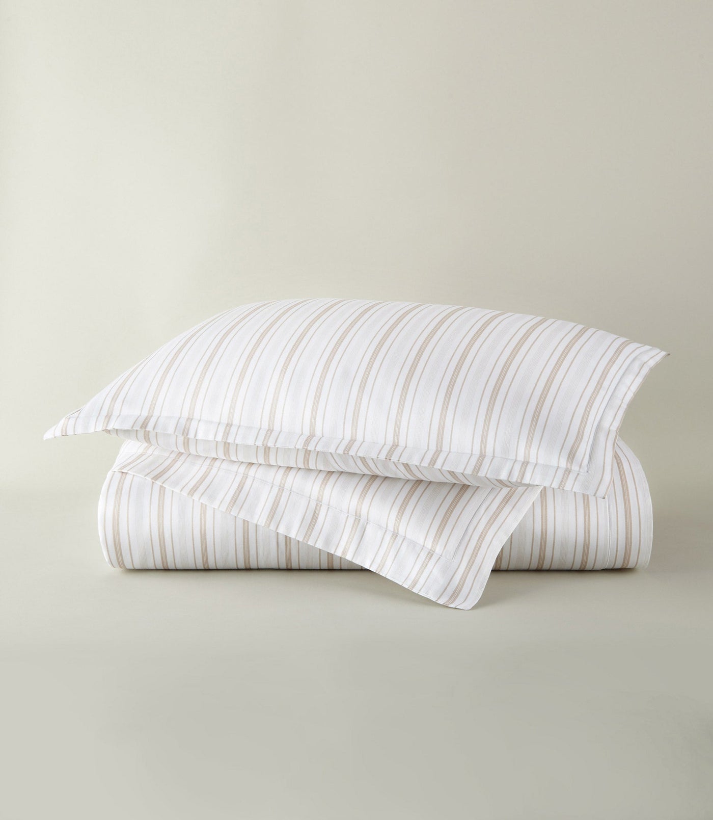 Peacock Alley Shelby duvet cover in white with tan and gray stripes, folded with sham.