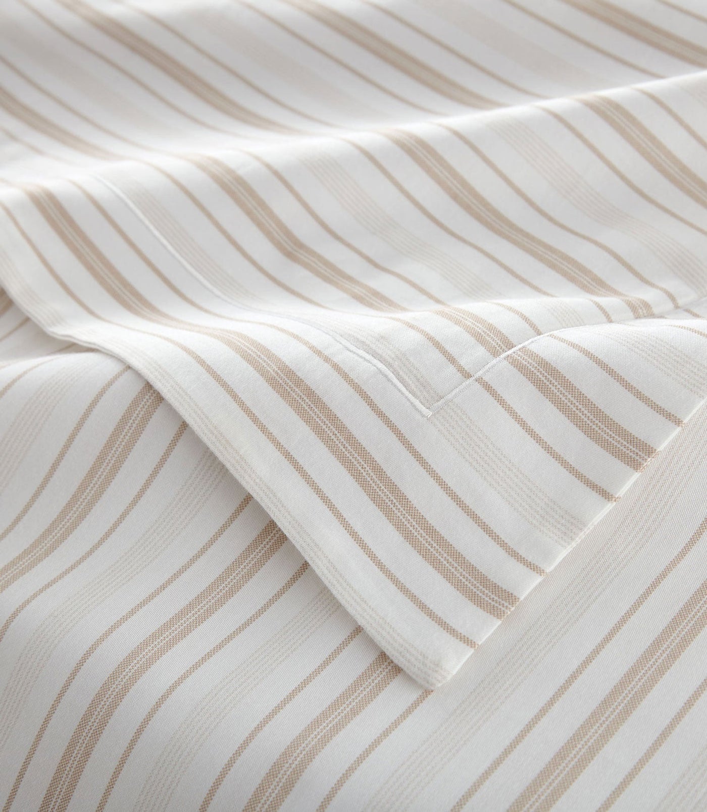 Close-up of sand stripe weave texture and folded hem detail on ivory cotton.