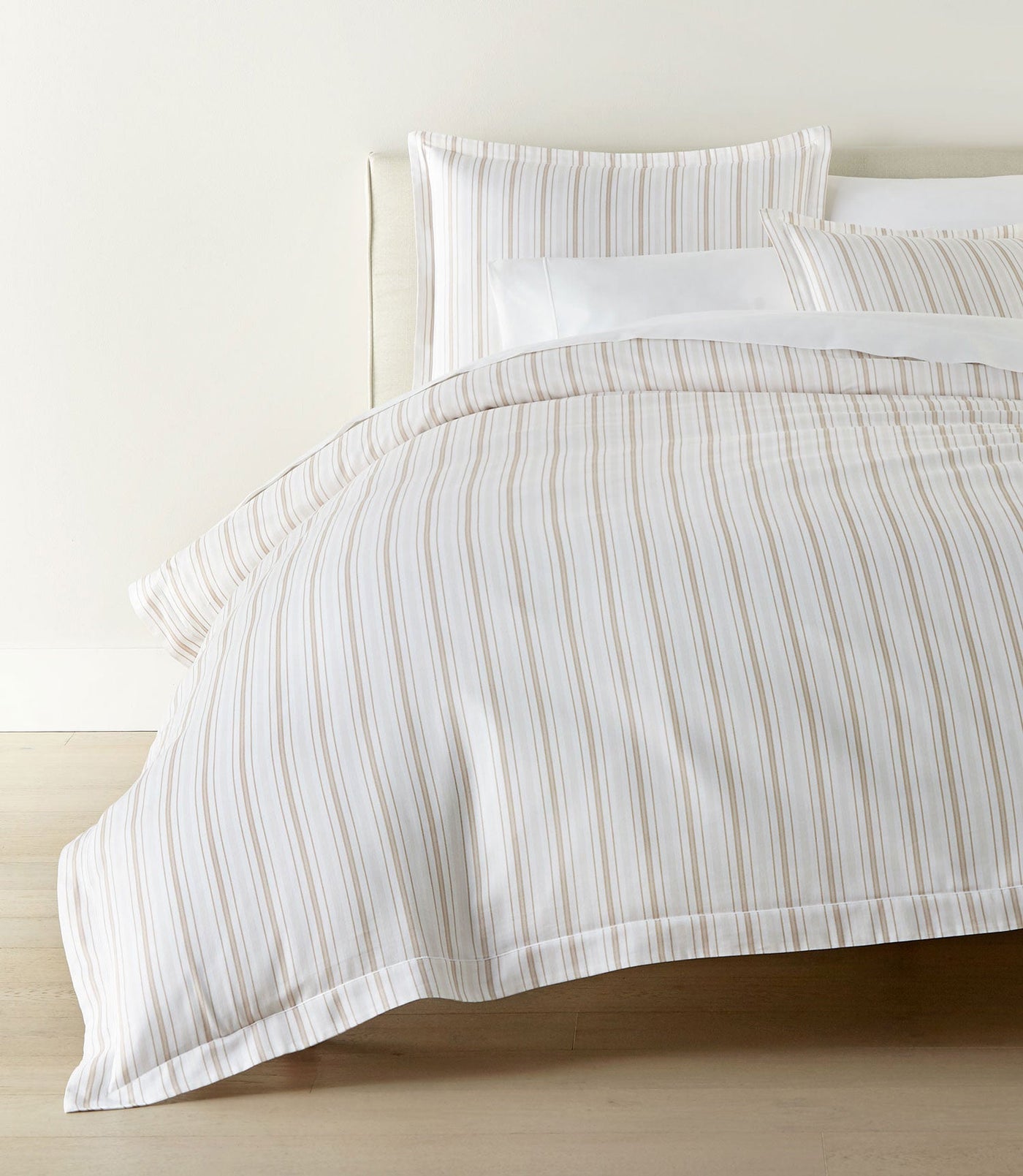 Duvet cover draped over bed showing full sandy stripe pattern on white ground.