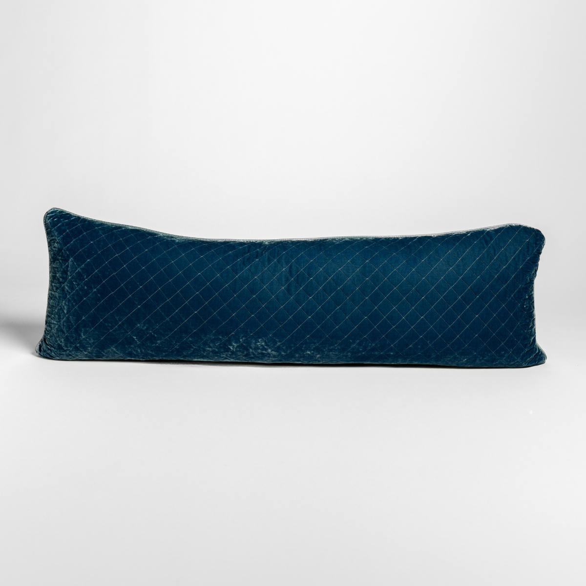 Bella Notte quilted lumbar pillow in Tahoe Blue velvet, diamond-stitched surface, side profile view.