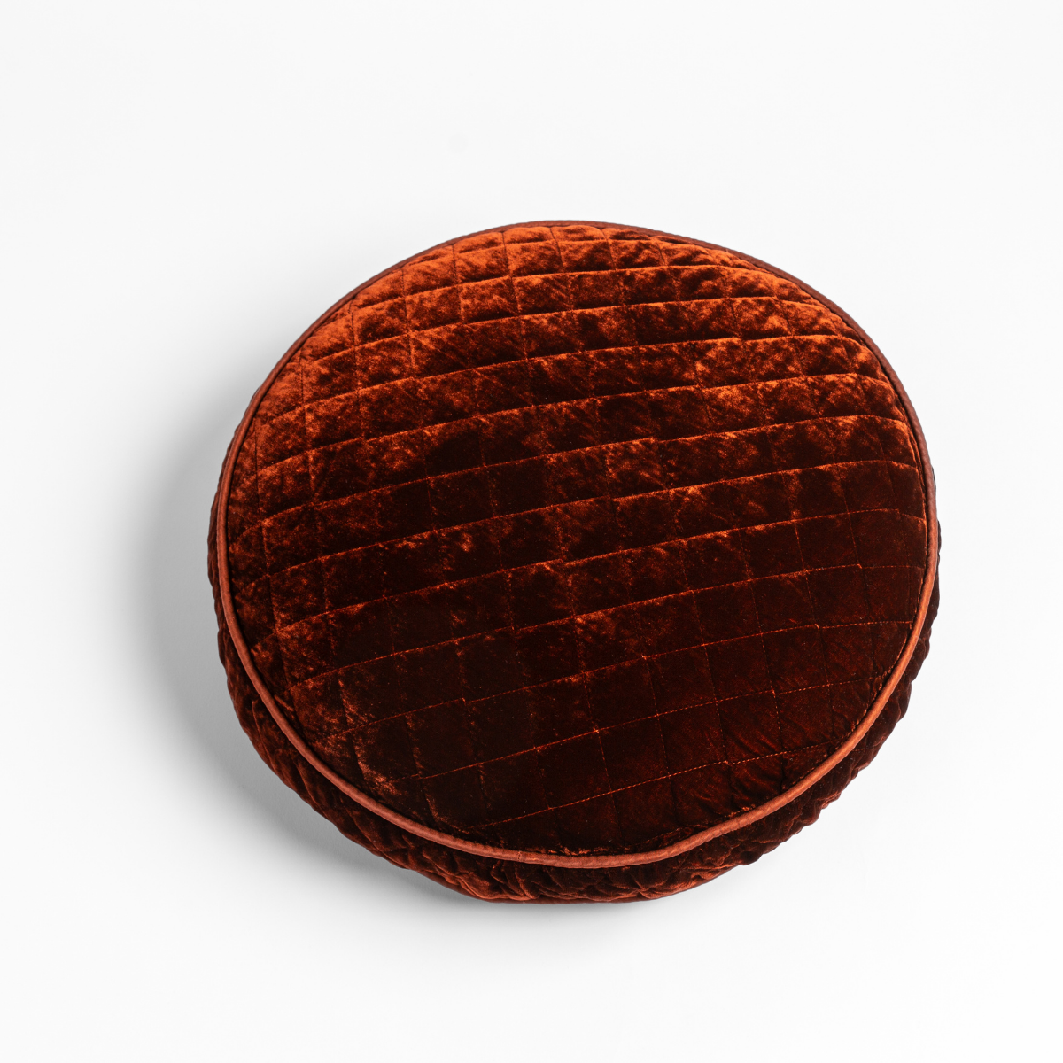 Overhead view of Autumn quilted silk velvet round throw pillow with piped edge.