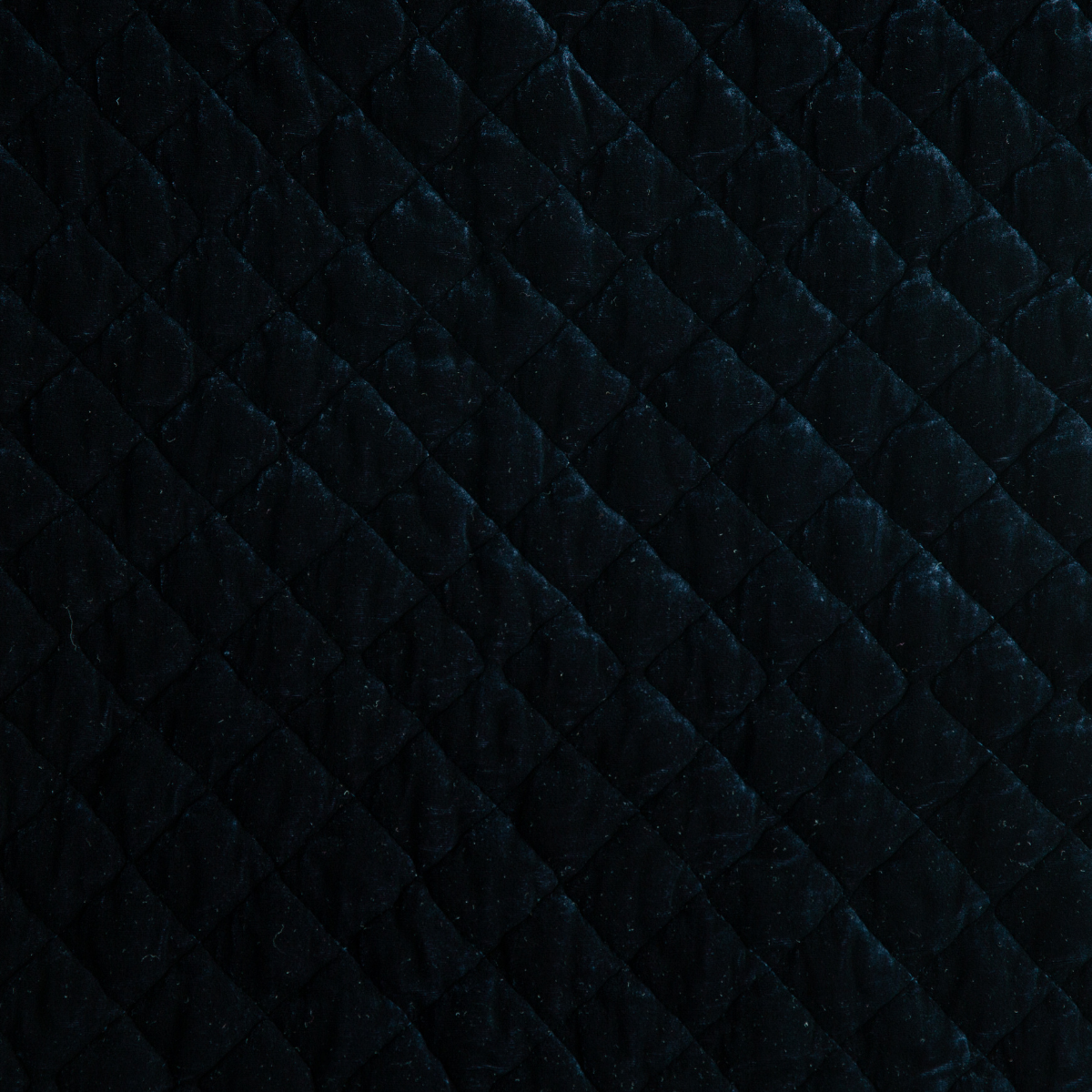 Close-up of Midnight silk velvet quilted texture with diamond stitching pattern.