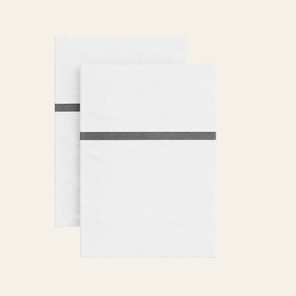 Ann Gish Silk Trim pillowcases in white with charcoal silk band detail, pair shown folded.