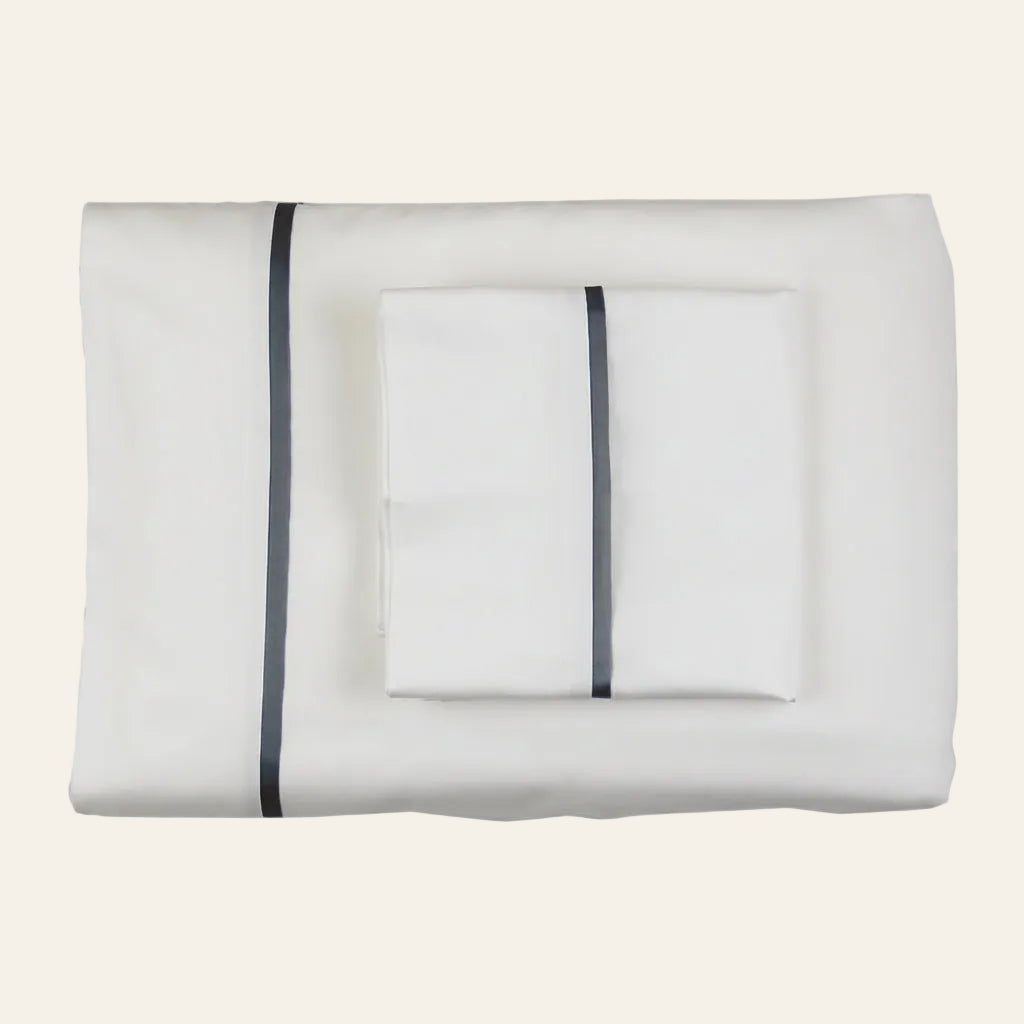 Ann Gish Silk Trim sheet set in white with charcoal silk trim, folded flat lay.