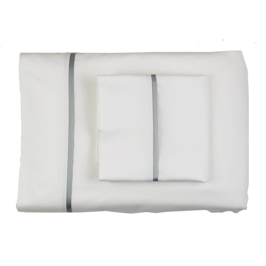 Folded white silk sheet set with grey trim detail, shown with matching pillowcases.