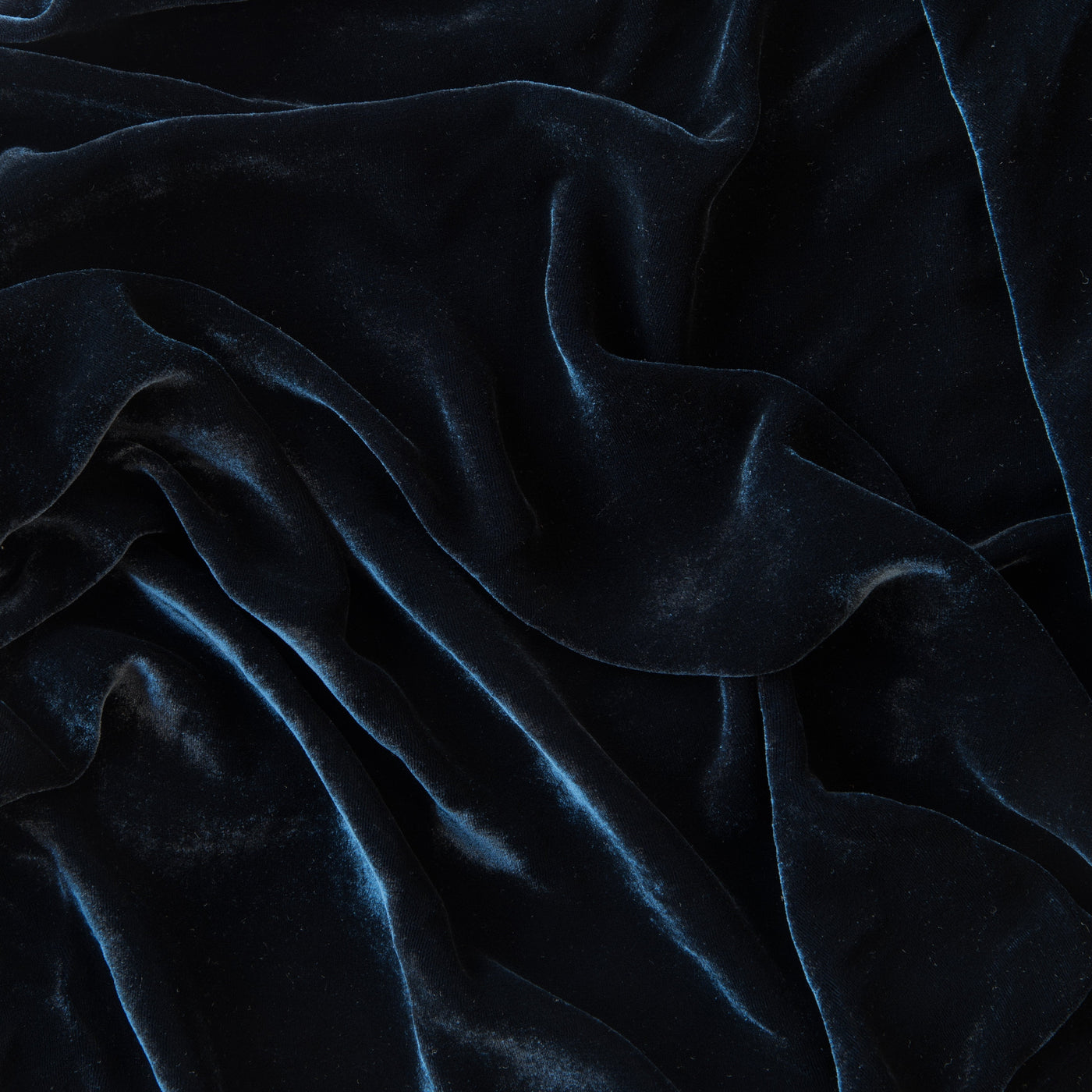 Close-up of Midnight velvet fabric with deep folds highlighting the plush, lustrous texture.