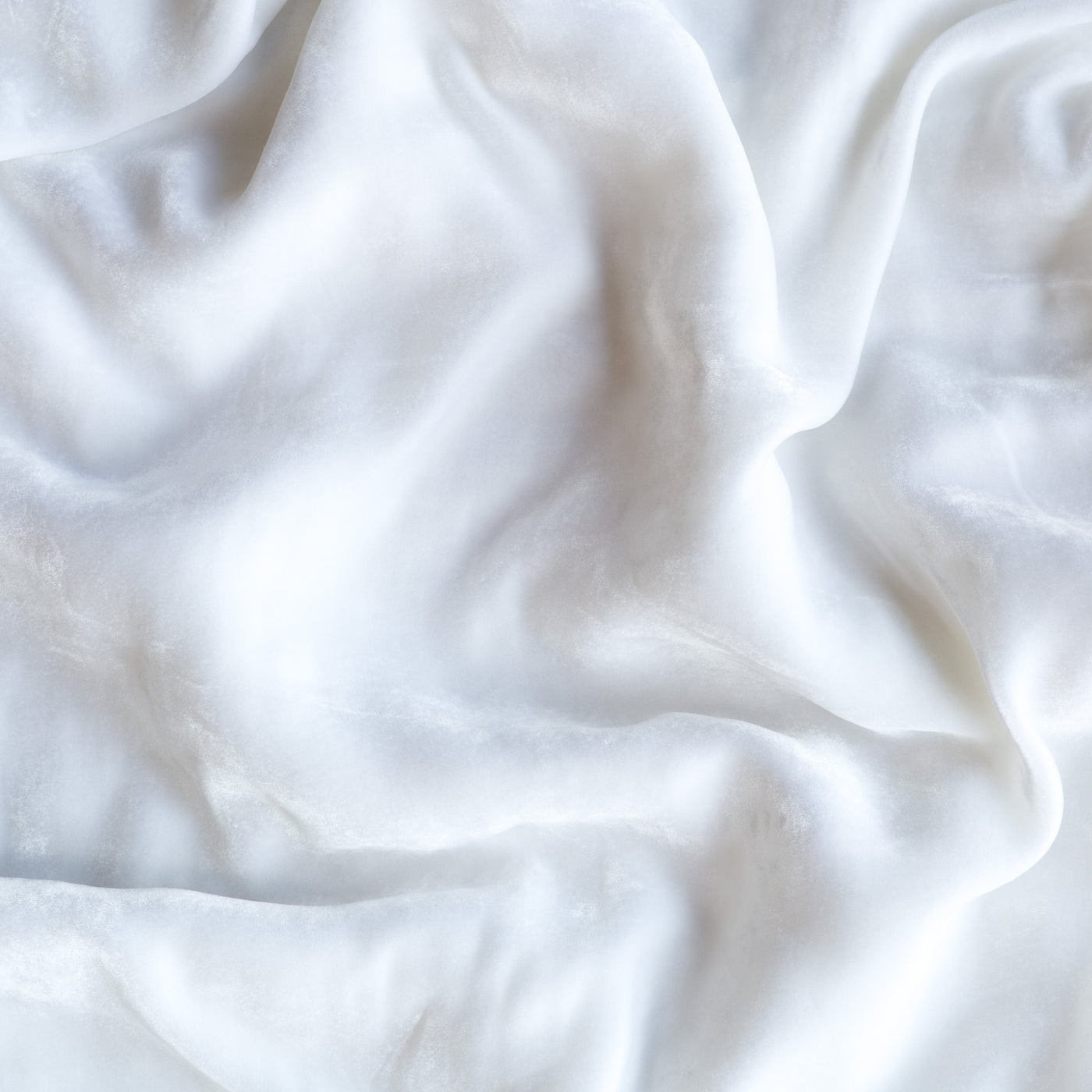 Softly draped White fabric showing relaxed folds and subtle sheen of Bella Notte Loulah throw.
