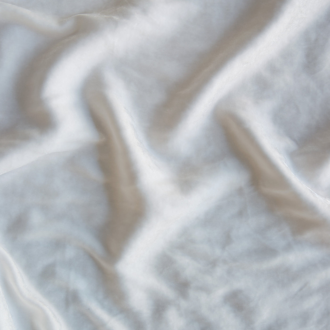 Close-up of draped Winter White fabric showing soft folds and delicate sheen.