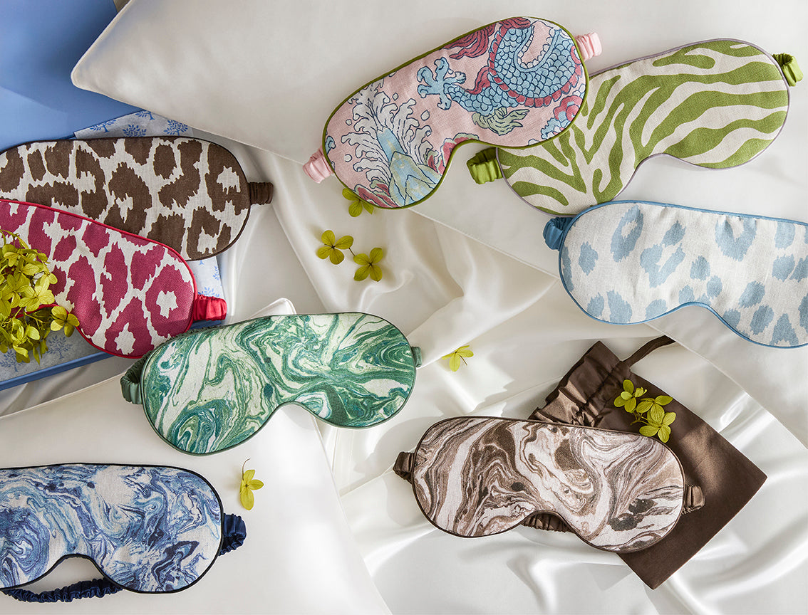 Matouk Valentina linen sleep masks in assorted prints on white fabric.