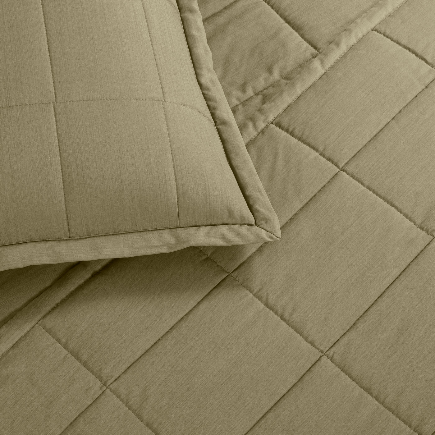 Close-up of sage quilted Tencel coverlet corner with box stitch pattern and matching sham edge.