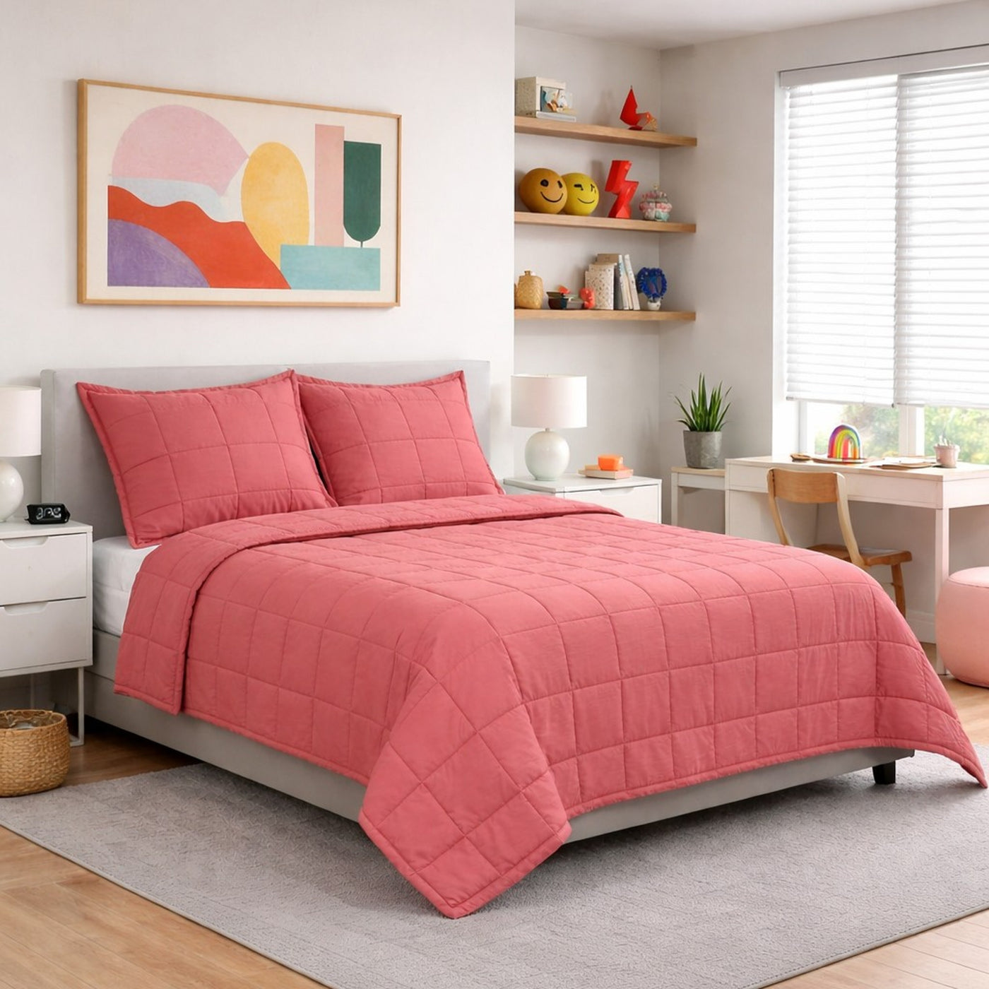 Coral quilted coverlet set styled on a full bed in a bright, modern bedroom.