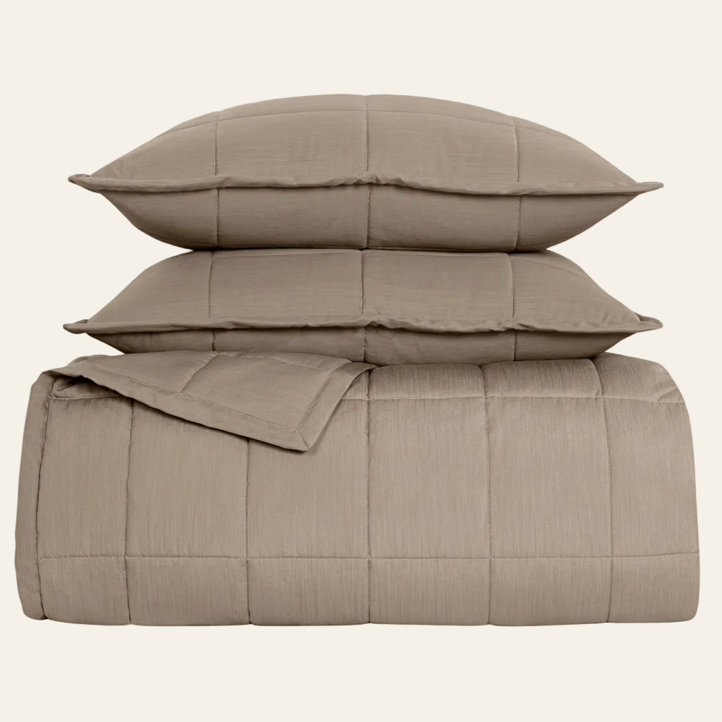 Ann Gish Slub Tencel coverlet set in taupe, folded with two matching pillow shams stacked.