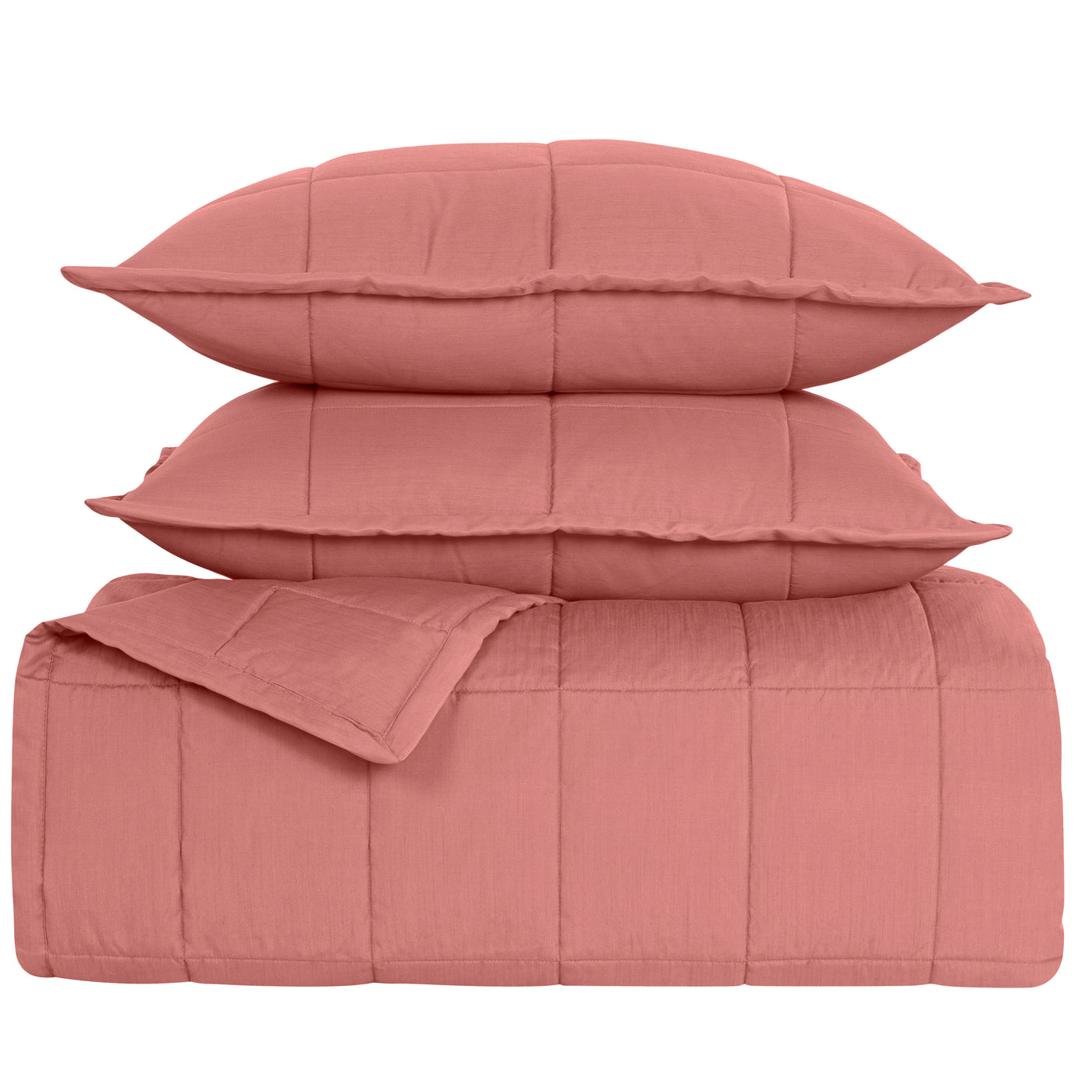 Close-up of Ann Gish Slub Tencel coverlet set in coral pink, folded with two pillow shams stacked.