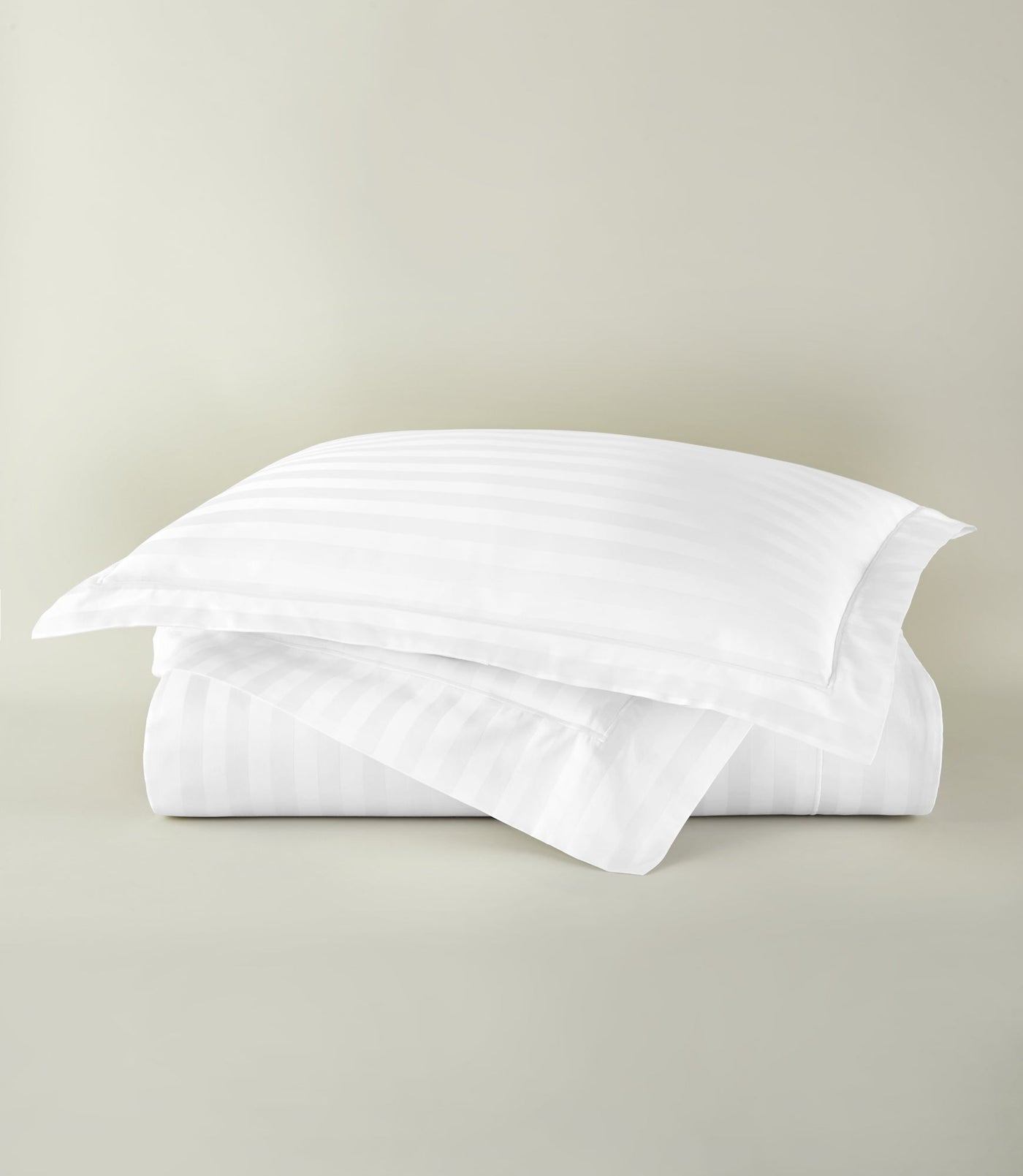 Peacock Alley Soprano Stripe duvet cover in white with tone-on-tone satin stripes, neatly folded.