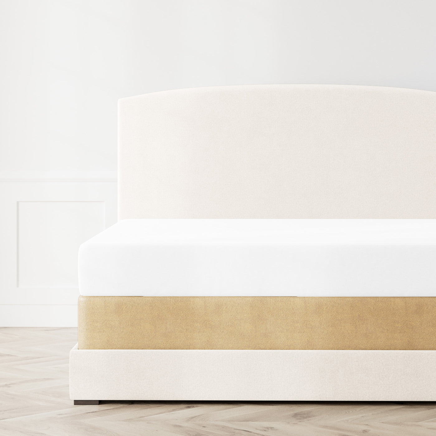 Ann Gish Stardust box spring cover in gold, styled on a bed with white fitted sheet.