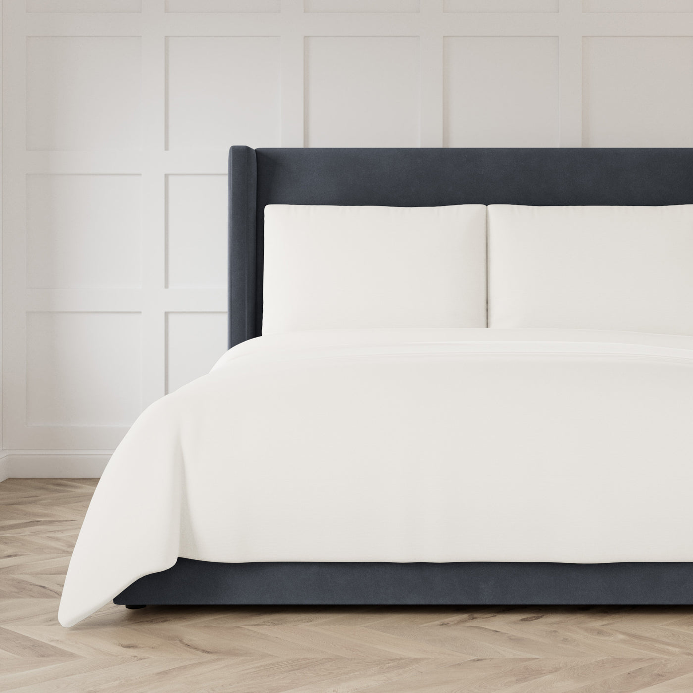 Ann Gish Strata coverlet in ivory, styled on a charcoal upholstered bed.