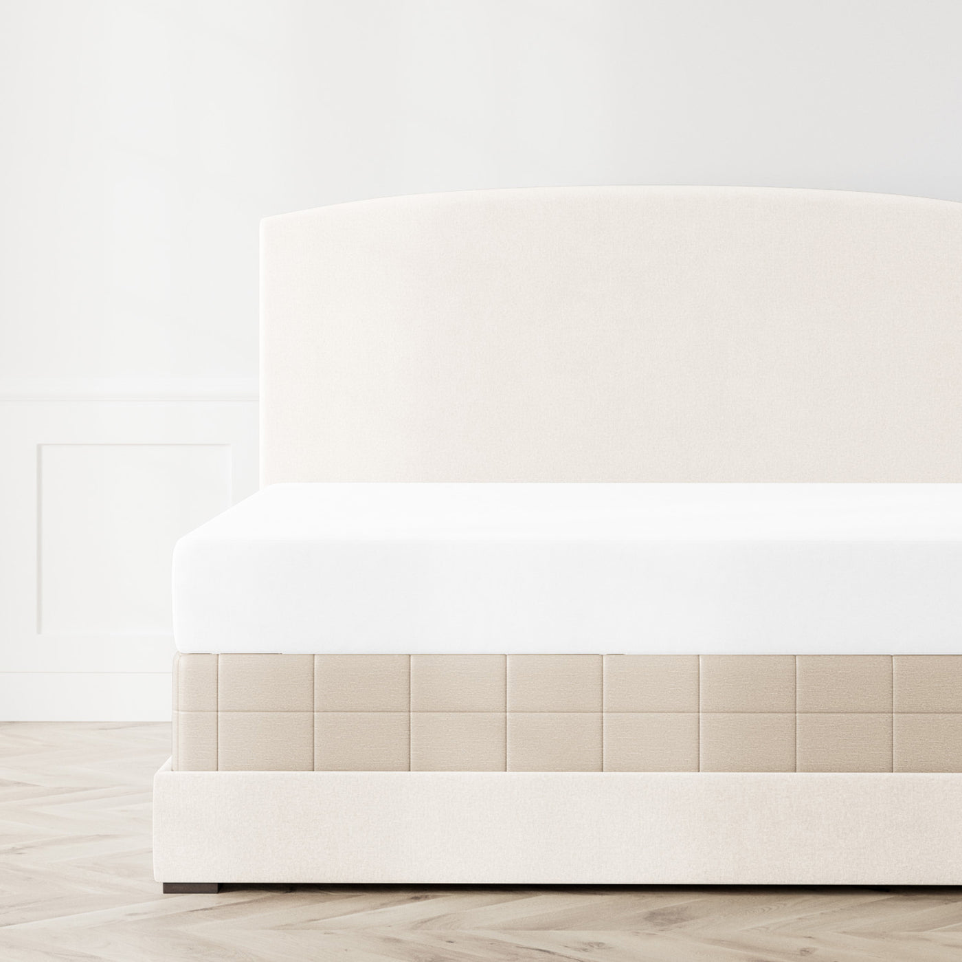 Ivory Ann Gish Stria box spring cover on an upholstered bed, front angle view.