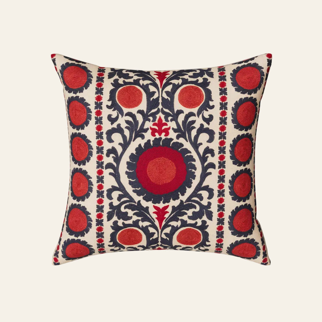 Ann Gish Suzani pillow in ivory with red and navy embroidered medallion pattern.