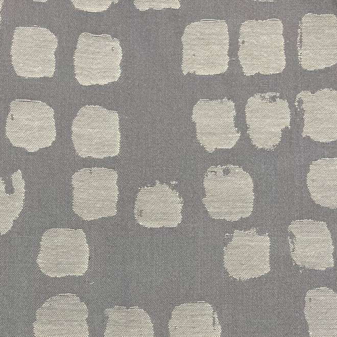 Close-up of Ann Gish Antilles duvet fabric in slate grey with ivory brushstroke square pattern.