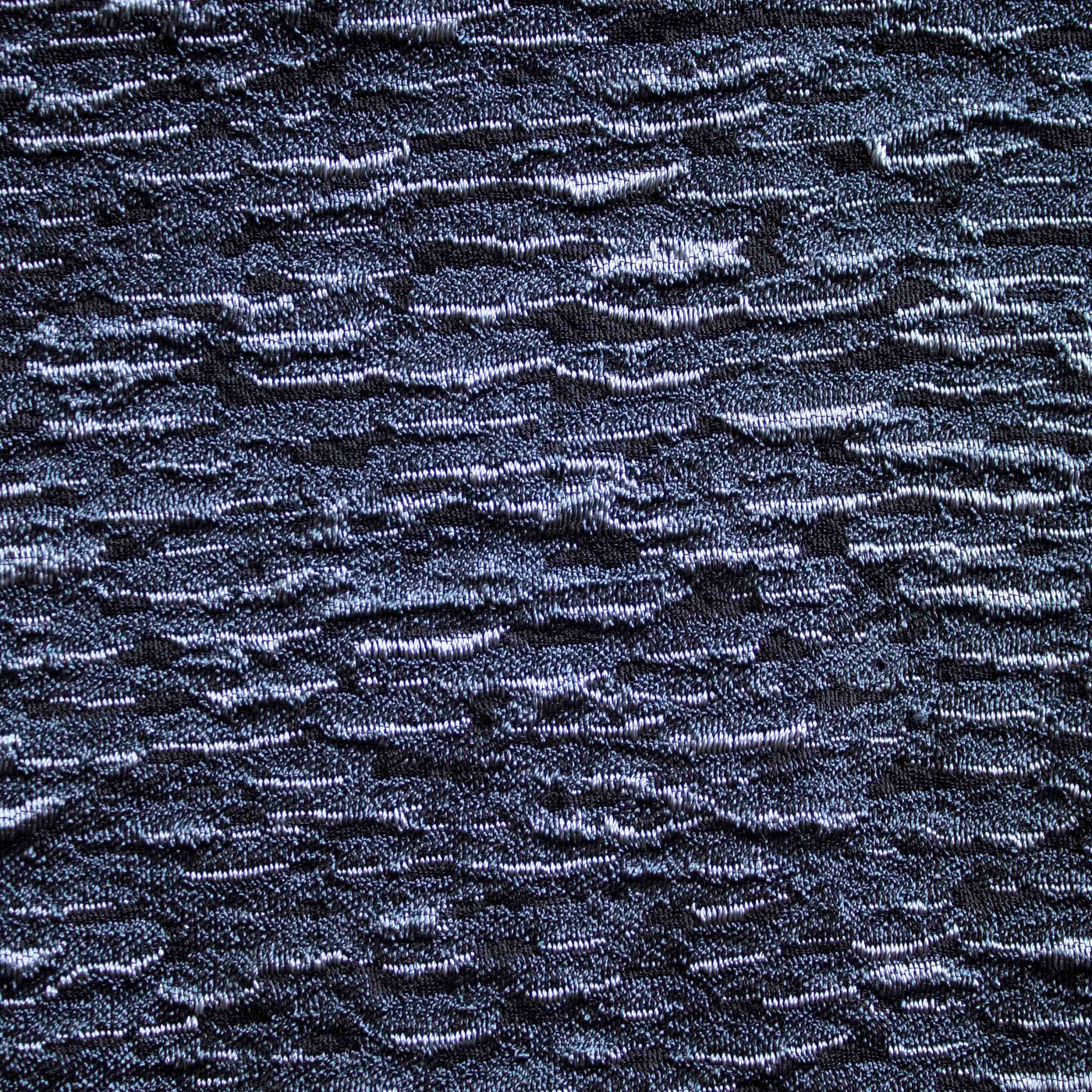 Close-up of Ann Gish Asperitas coverlet in midnight blue with textured woven surface.