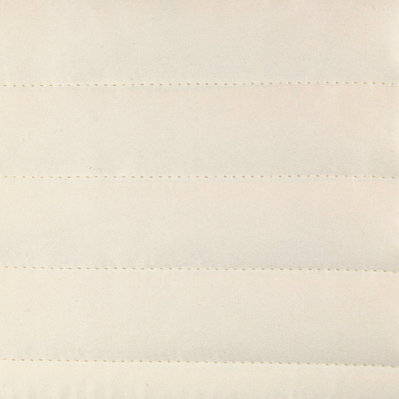 Close-up of ivory charmeuse fabric with horizontal channel stitching detail.